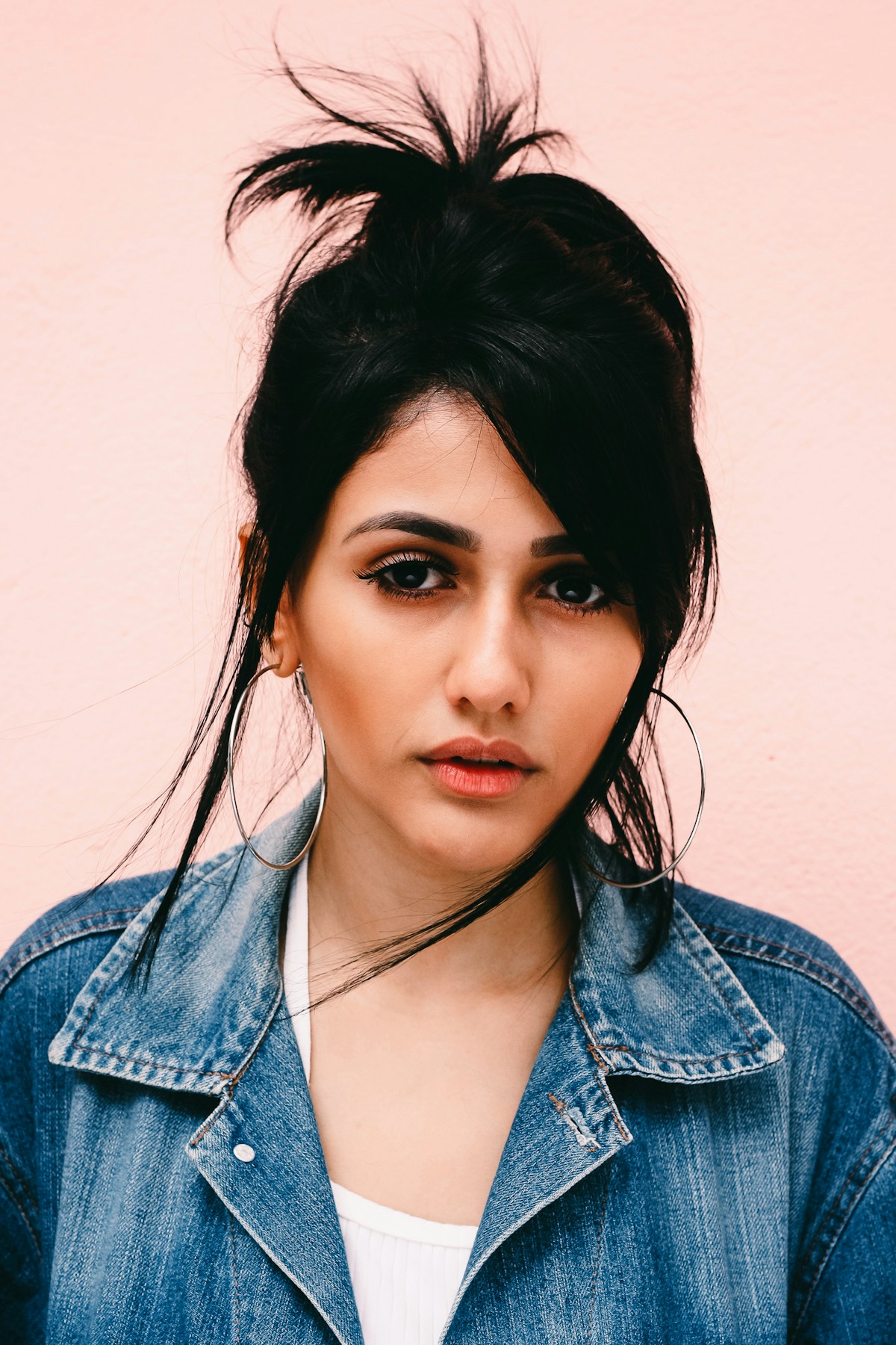 Editorial portrait of a woman in a soft pink setting